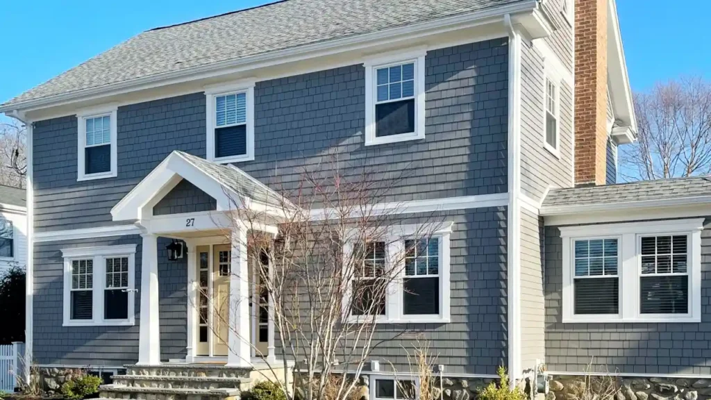 Board and Batten Exterior Massachusetts colonial home with charcoal Hardie board siding and white trim