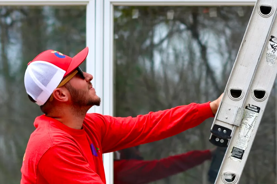 Installer setting a replacement window into an existing Framingham home opening