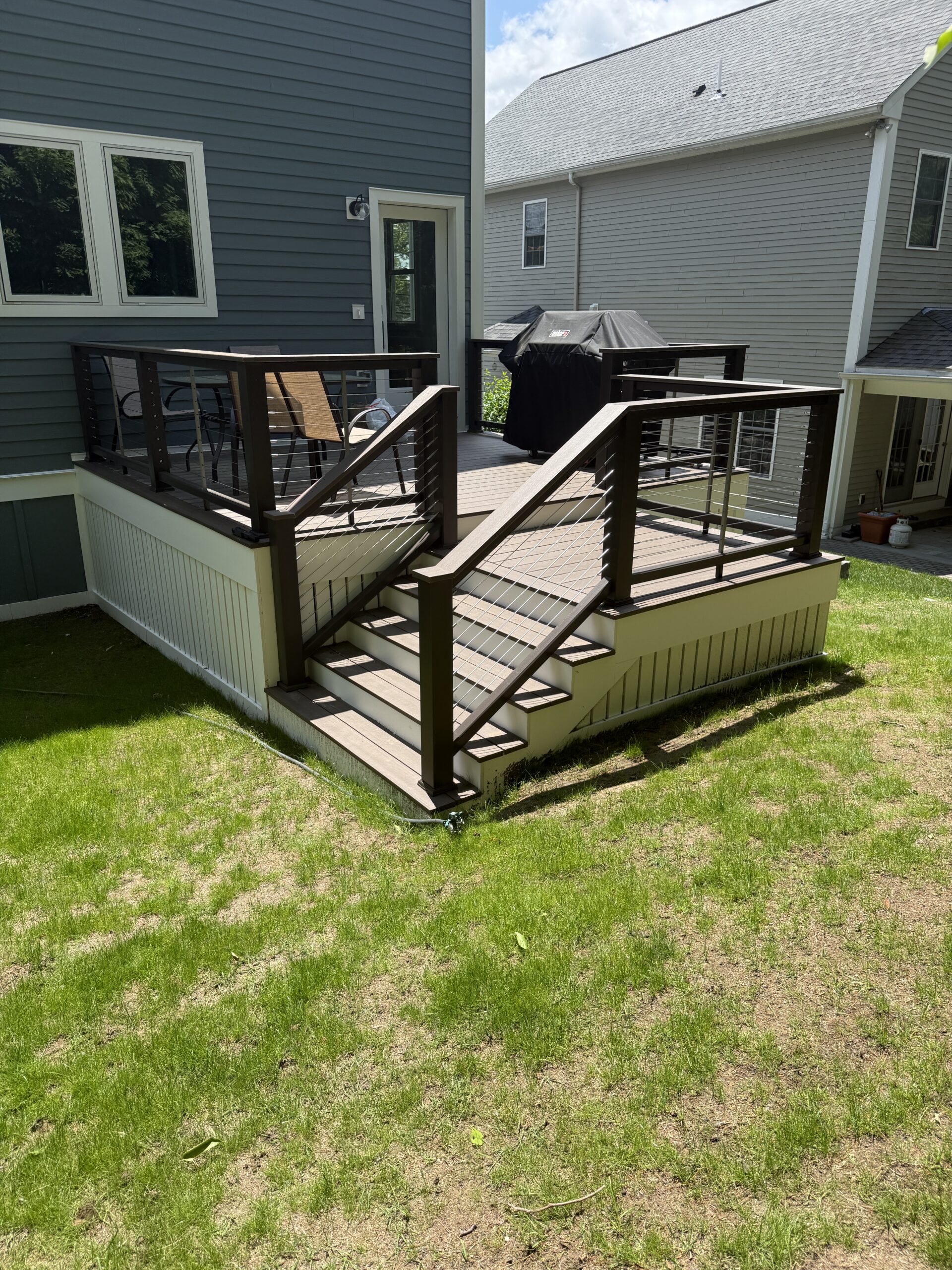 Composite deck with cable railings and stairs to the yard