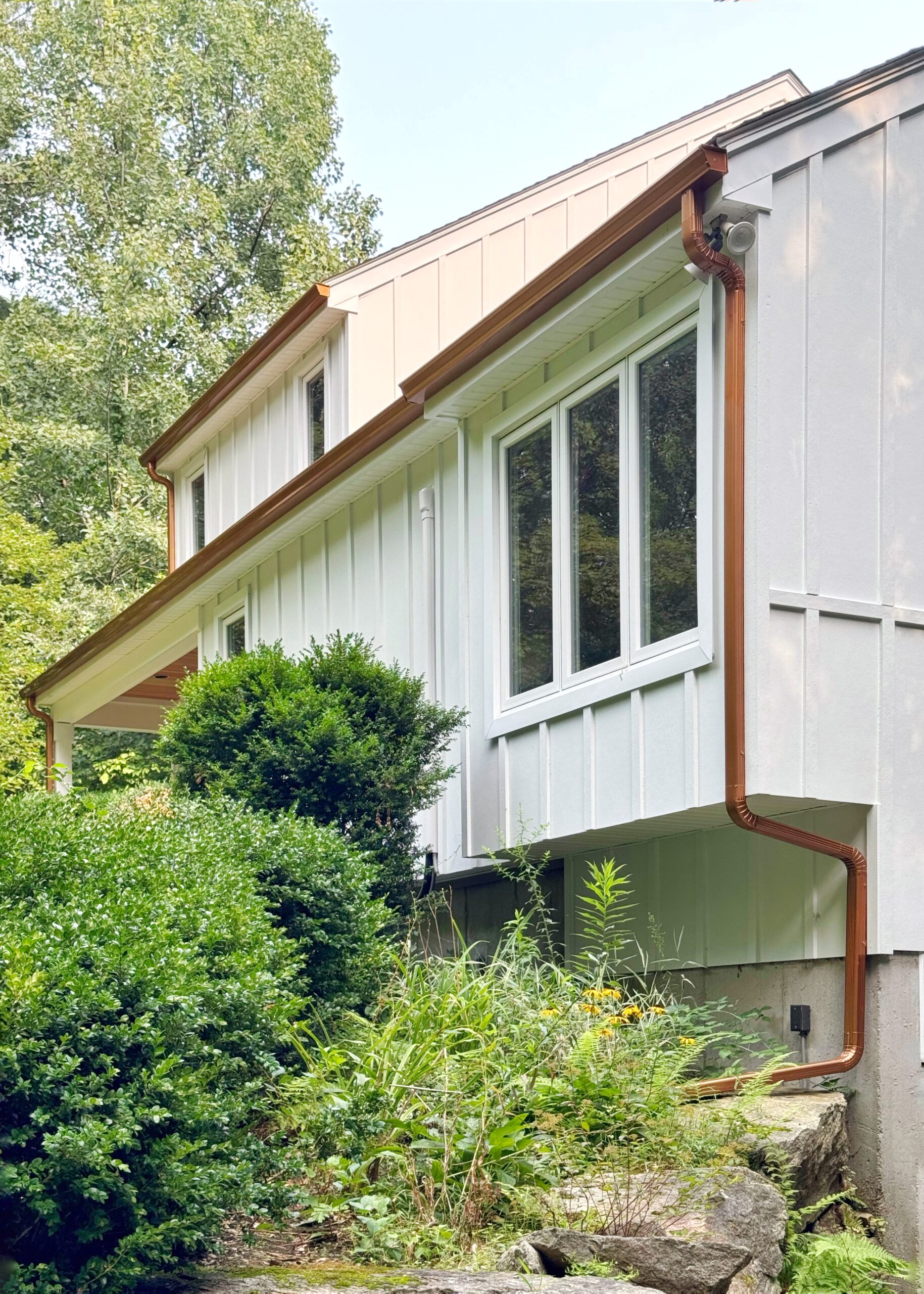 Copper gutters and downspout on white board-and-batten siding