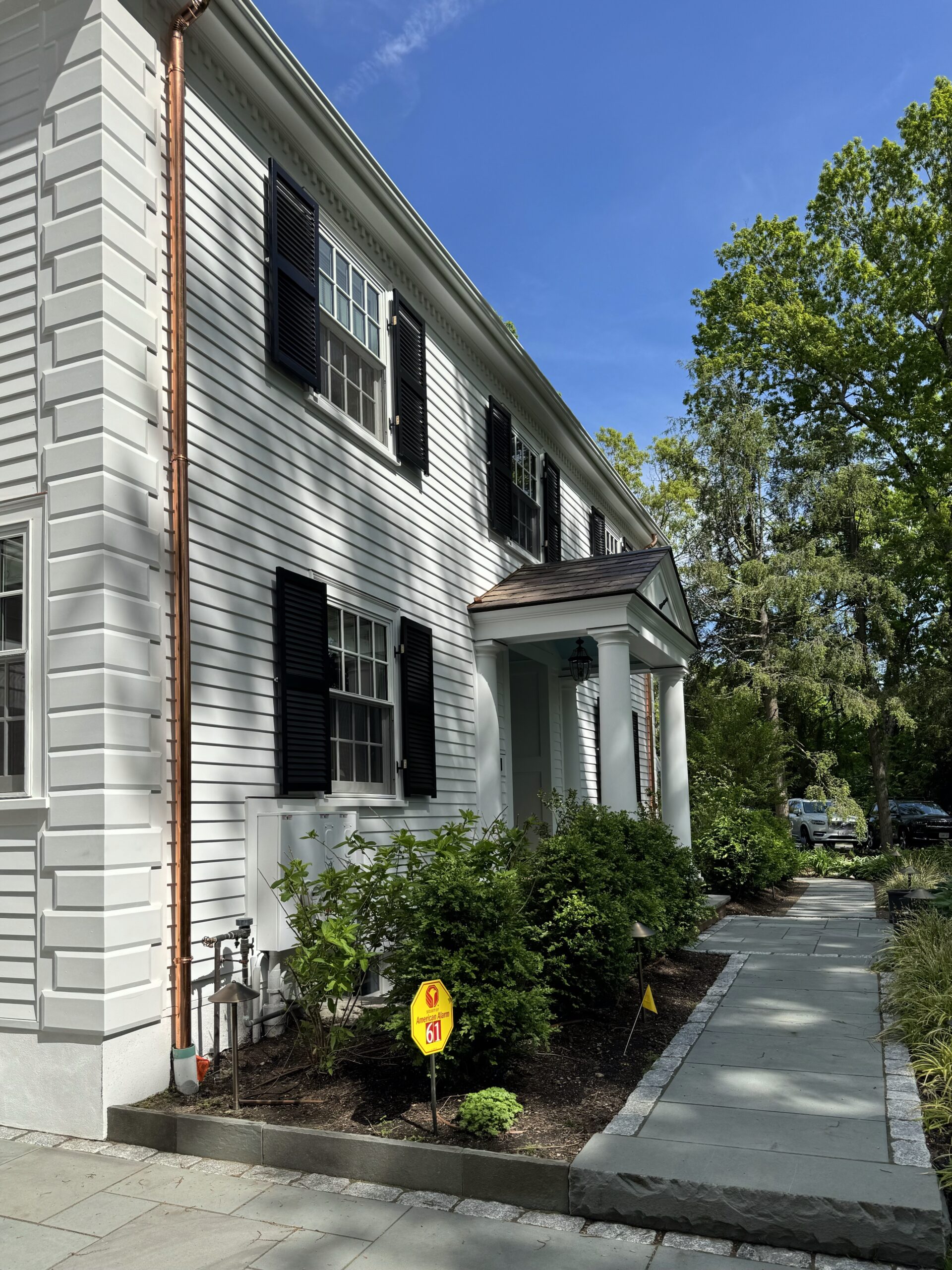 Copper downspout on a white colonial