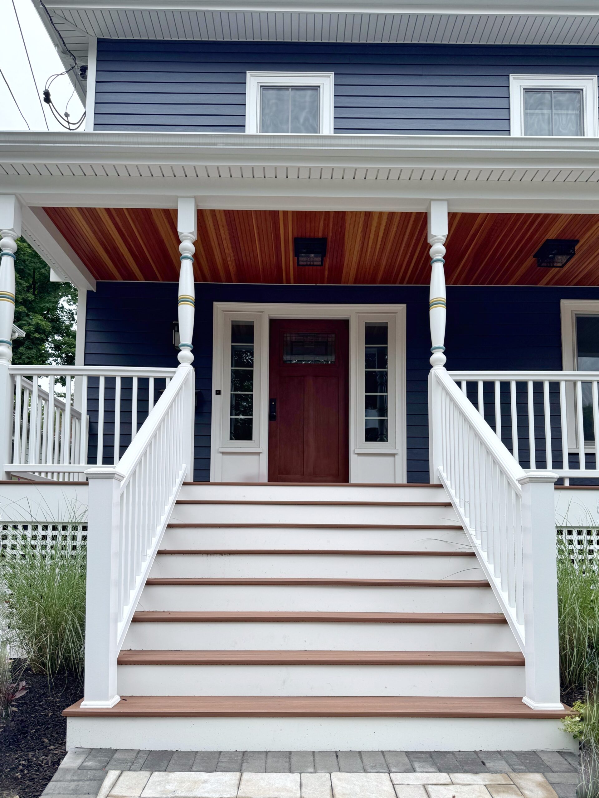 Farmer's porch with a cedar ceiling on a navy home in Wellesley