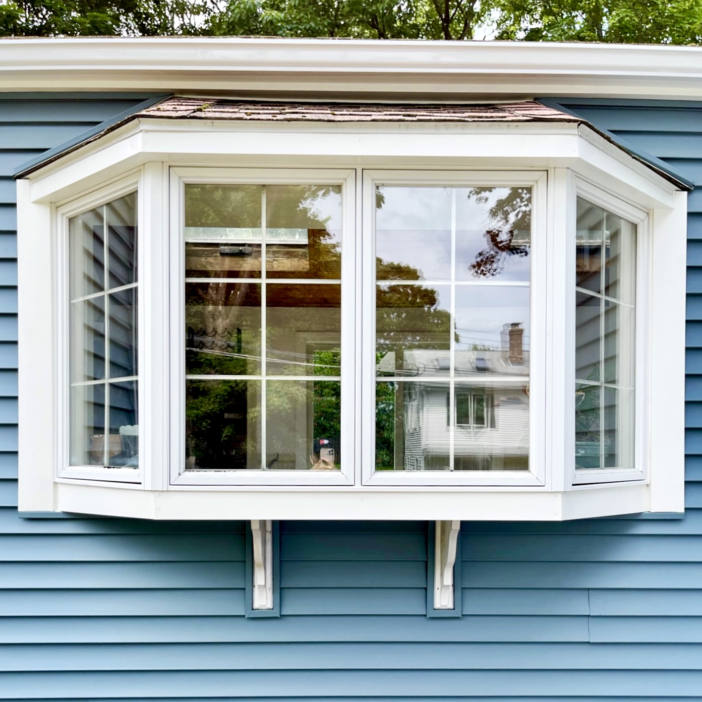 White bay window on blue siding